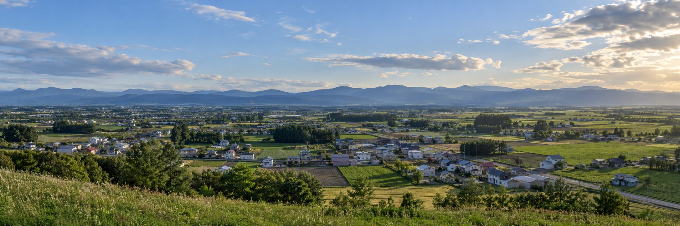 北海道の田園と街並みを想起させる風景のイメージ